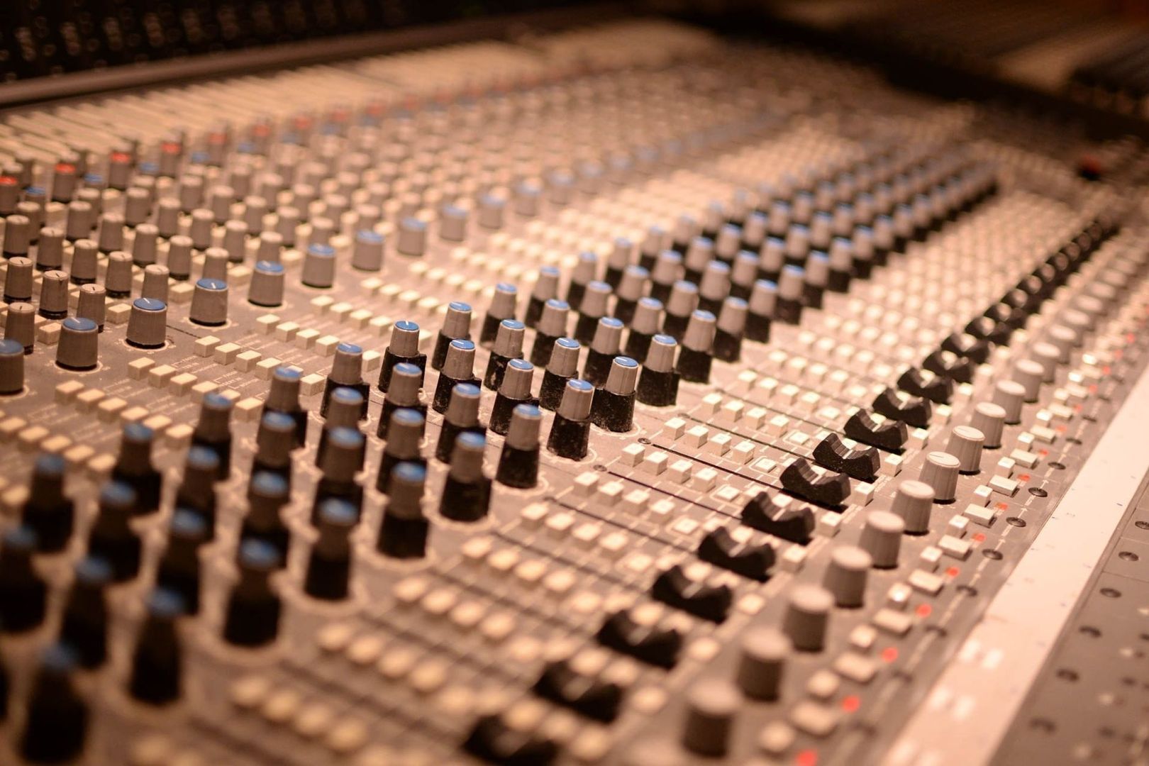 Nahaufnahme eines analogen Audiomischpults mit zahlreichen Reglern und Tasten